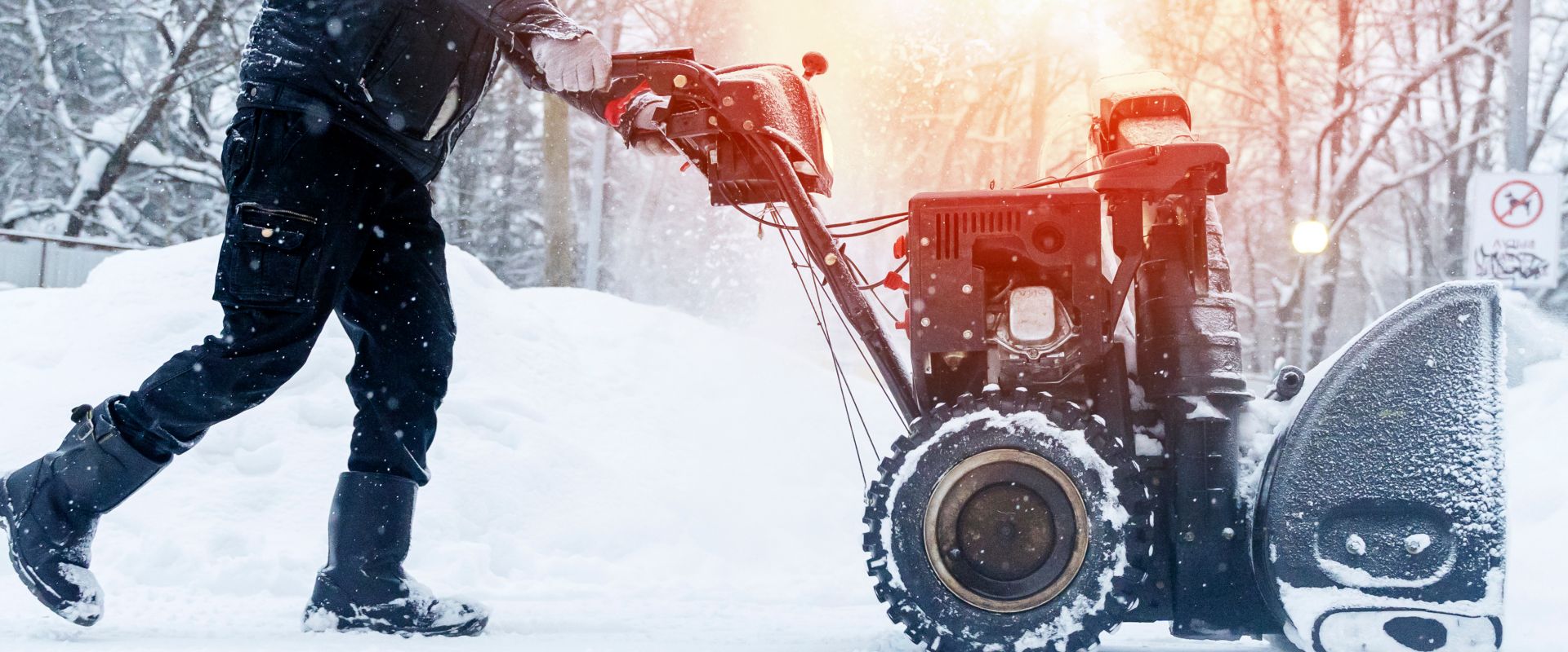 Eine Person schiebt einen Schneepflug über eine verschneite Fläche